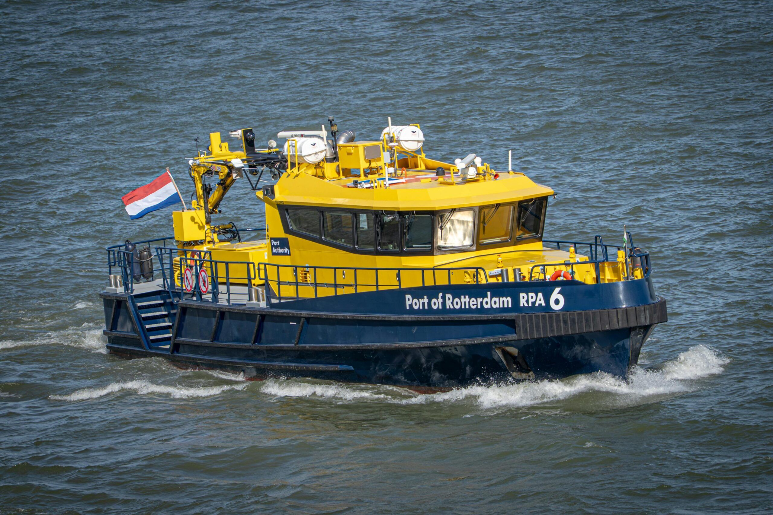 Havendienstboot vaart voorbij tijdens een rondvaart door haven van Rotterdam